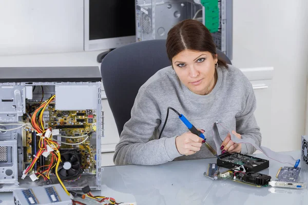 Retrato de jovem senhora solda componente de computador — Fotografia de Stock