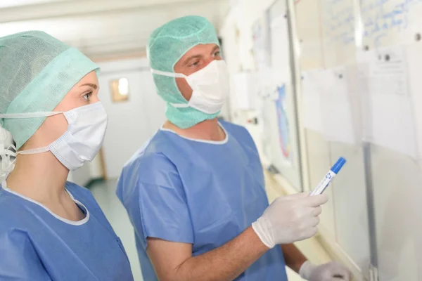 Medizinisches Personal schaut auf Whiteboard — Stockfoto