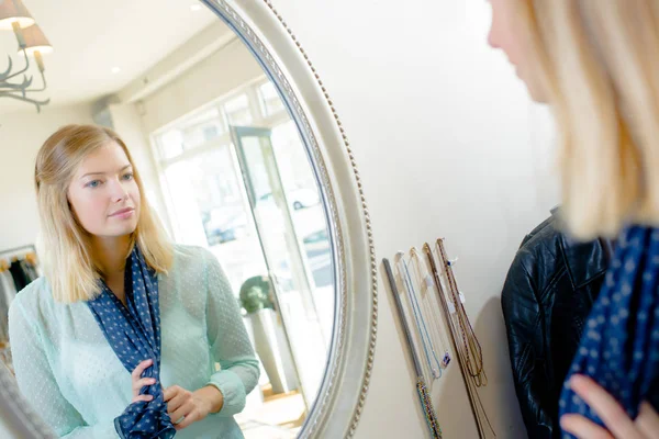 Lady bär scarf tittar på reflektion i spegeln — Stockfoto