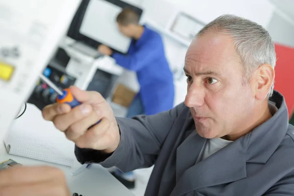 Young technician in lab coat repairing computer — Stock Photo, Image
