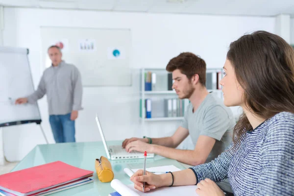 Estudantes internacionais e professor de pé na placa branca na palestra — Fotografia de Stock