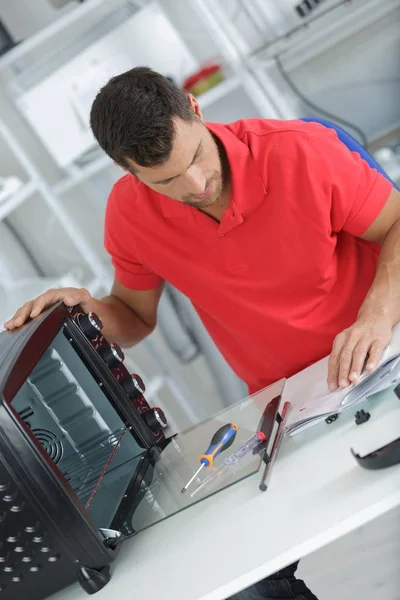 Man installing new oven in a kitchen — Stock Photo, Image