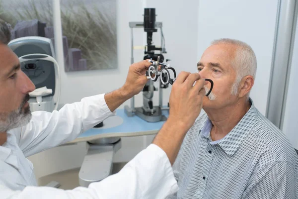 Oftalmólogo poner gafas de prueba en el paciente —  Fotos de Stock