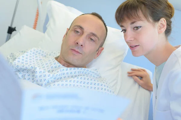 Женщина-хирург задает пациенту несколько вопросов — стоковое фото