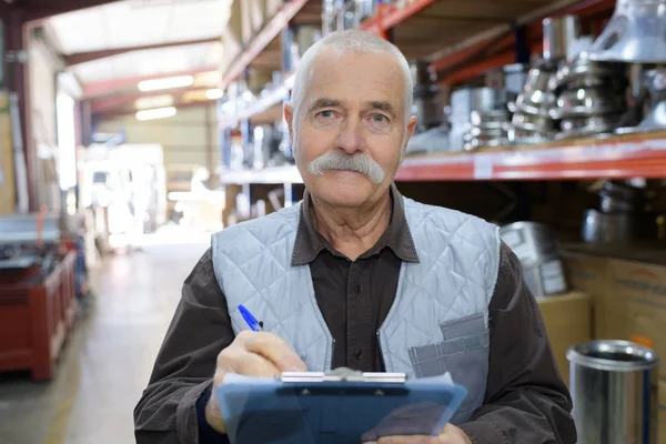 Trabajador senior en un almacén en una fábrica — Foto de Stock