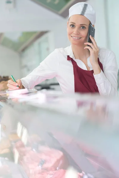 Slaktaren tar telefon order — Stockfoto