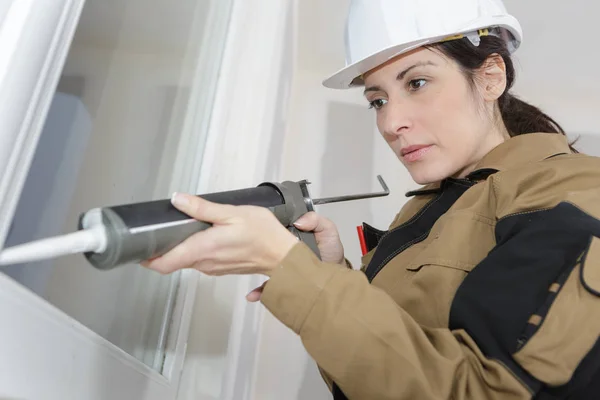 Mujer trabajadora de la construcción instalando ventana en casa —  Fotos de Stock