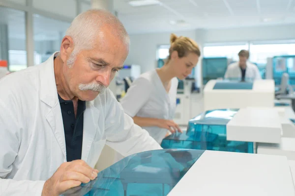 Äldre forskare använder maskinen på laboratorium — Stockfoto