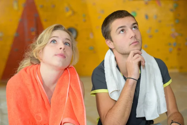 Young couple looking up at climbing wall — Stock Photo, Image