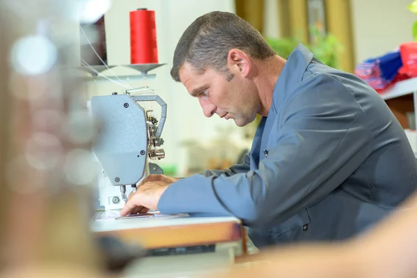 Hombre de mediana edad utilizando la máquina de coser —  Fotos de Stock