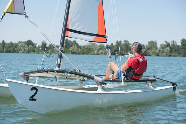 Mann segelt mit Segeln an einem sonnigen Tag — Stockfoto