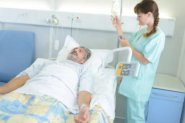 Жінка медсестра з пацієнтом у ліжку — стокове фото