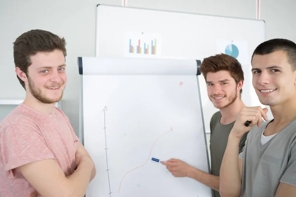 Giovani uomini che fanno una presentazione aziendale a un gruppo — Foto Stock