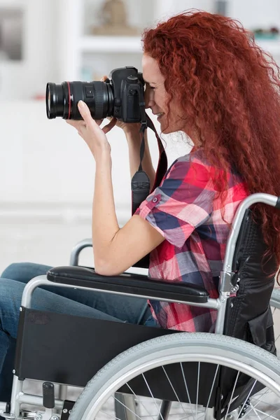 Инвалидная женщина в инвалидном кресле увлекается фотографией — стоковое фото
