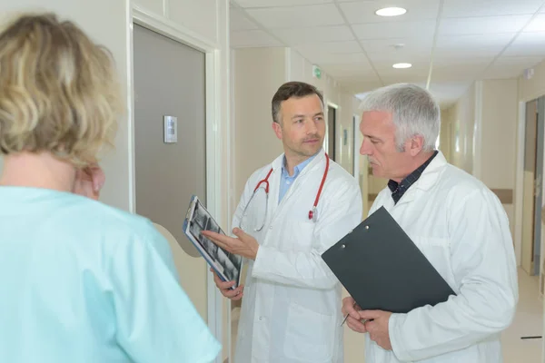 Personnel médical regardant les rayons X à l'extérieur de la chambre d'hôpital — Photo