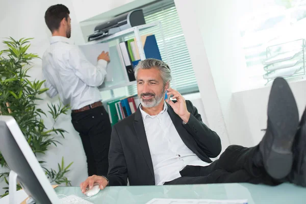 Entspannter Geschäftsmann mit erhobenen Füßen — Stockfoto