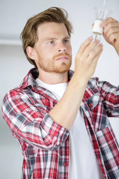 Handsome electrician changing classical bulb — Stock Photo, Image