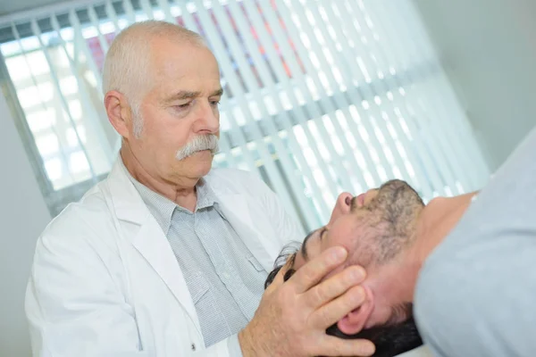Chiropraktiker hält Patientenkopf — Stockfoto