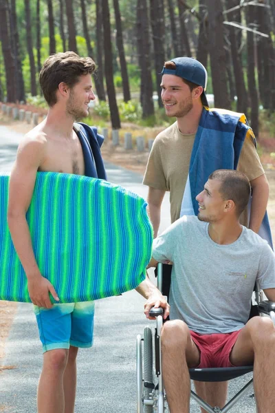3 pojkar anländer till stranden ett inaktiveras — Stockfoto