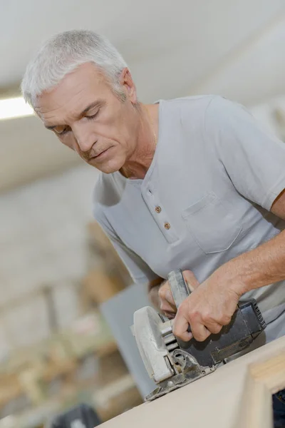 Ervaren timmerman met behulp van een cirkelzaag — Stockfoto