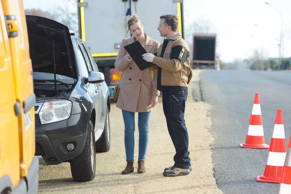 Frau mit Bergungsfahrer neben der Straße — Stockfoto