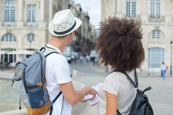 Visão traseira do livro guia de exploração casal na cidade — Fotografia de Stock