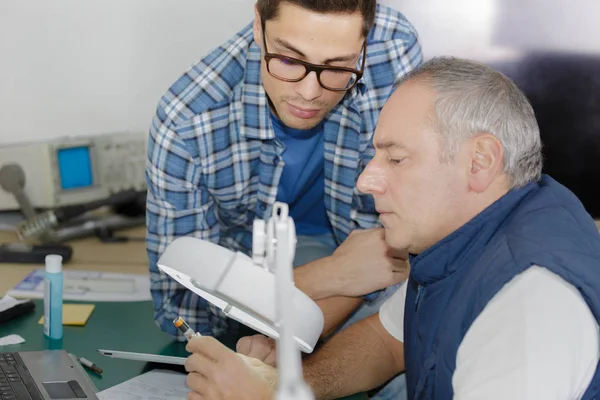 Soldeerbout gebroken gedemonteerde elektronische onderdelen door vergrootglas — Stockfoto