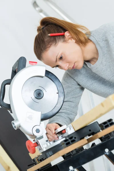 Female carpenter is using a circular saw — Stock Photo, Image