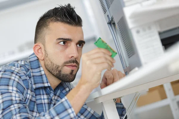 Jeune réparateur travaillant avec tournevis dans le centre de service — Photo