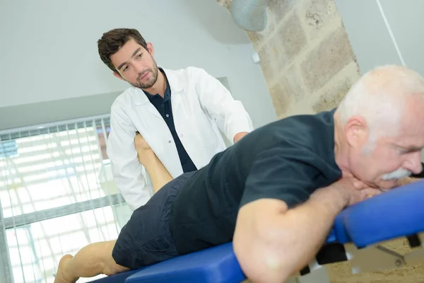 Chiropraktiker manipuliert Bein eines Seniors — Stockfoto