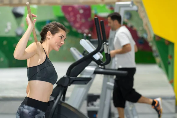 在健身房的跑步机上运行的运动型女人 — 图库照片