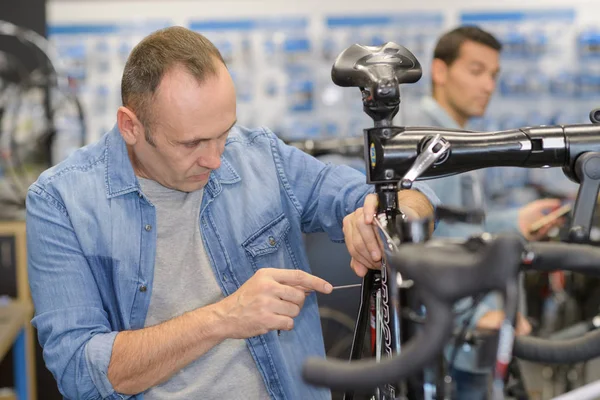 Reifer Mann repariert Rad im eigenen Laden — Stockfoto