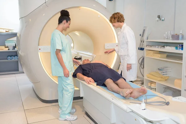 Open mri scanner with man in 40s undergoing test — Stock Photo, Image