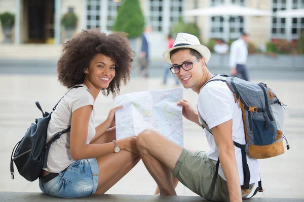 Tourist couple walking in sitting in the city and smiling — Stock Photo, Image