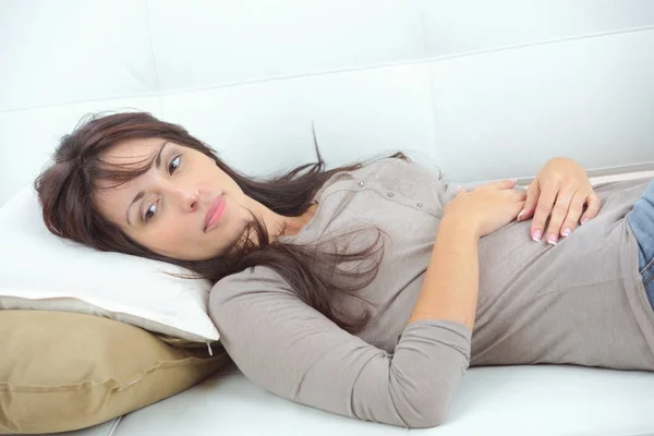 Woman lying down on the sofa — Stock Photo, Image