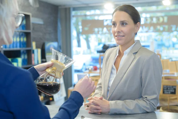 Kvinna som smakar kaffe på kafé — Stockfoto