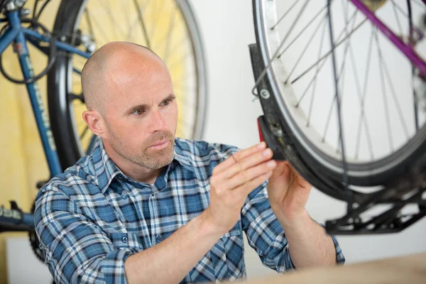 Jeune homme chauve réparer vélo — Photo