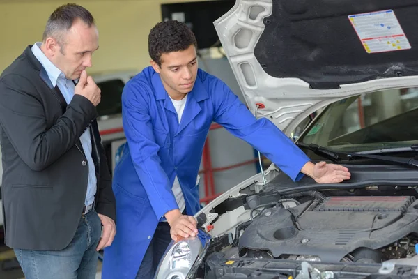 Profesor ayudando a los estudiantes a entrenar para ser mecánico de automóviles — Foto de Stock