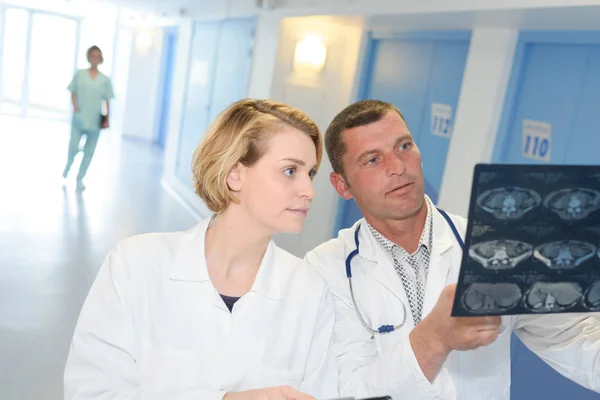 Pessoal médico a olhar para os raios X no corredor do hospital — Fotografia de Stock