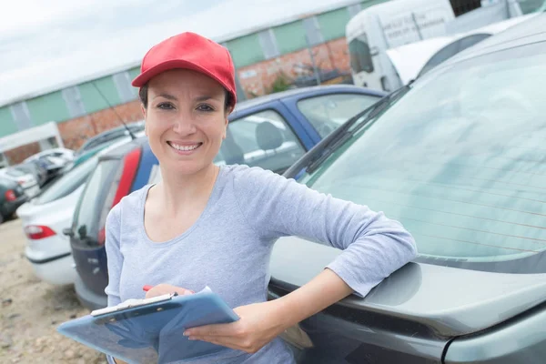 Bellissimo gestore cantiere rottami in posa con appunti e sorridente — Foto Stock