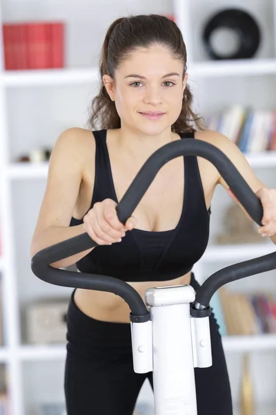 Passa brunett som träna på motionscykel — Stockfoto