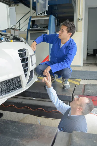 Twee monteurs werken aan een auto — Stockfoto