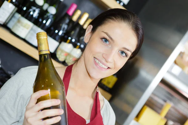 Winkelbediende die fles witte wijn — Stockfoto