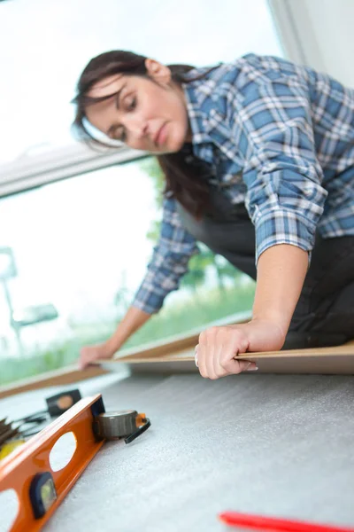 Trabalho feminino montagem piso de madeira — Fotografia de Stock