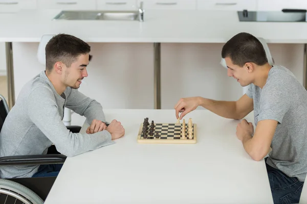 Giovani che giocano a scacchi, uno in sedia a rotelle — Foto Stock