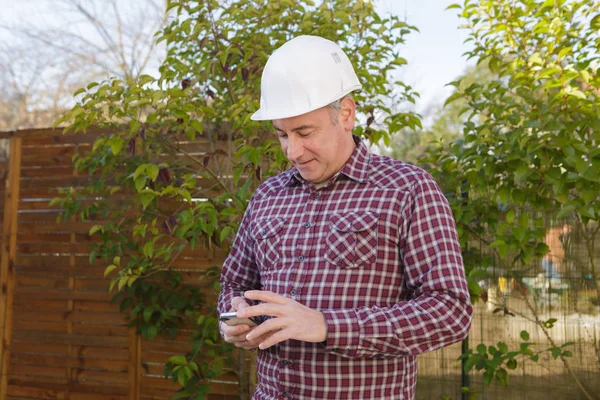 Trabalhador da construção usando telefone móvel — Fotografia de Stock