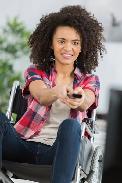 Vrolijke gehandicapte jonge vrouw thuis tv-kijken — Stockfoto