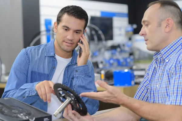 Säljaren reparera cykel wheel och småpratade med kunden — Stockfoto