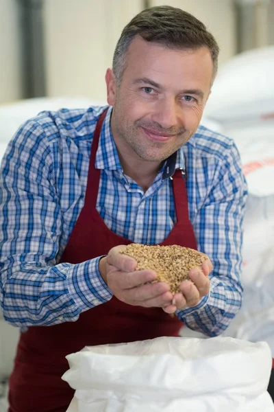 Portrait of man holding handful of grains — Stock Photo, Image