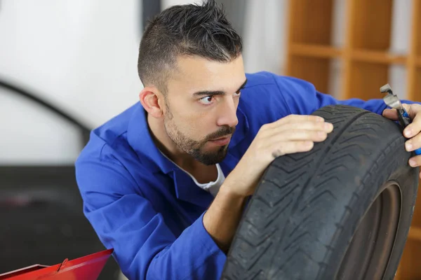Mechanik, kontrola hloubku vzorku na auto pneumatiky — Stock fotografie